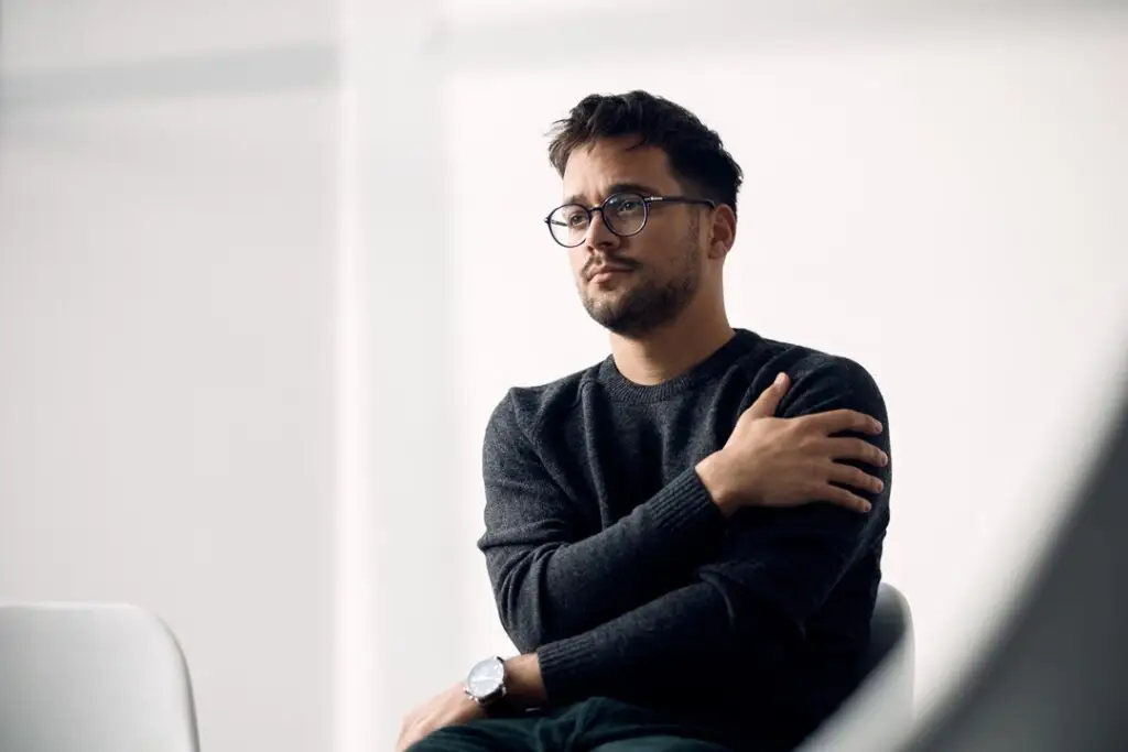 Young Distraught Man Waiting Group Therapy Start 1024x683